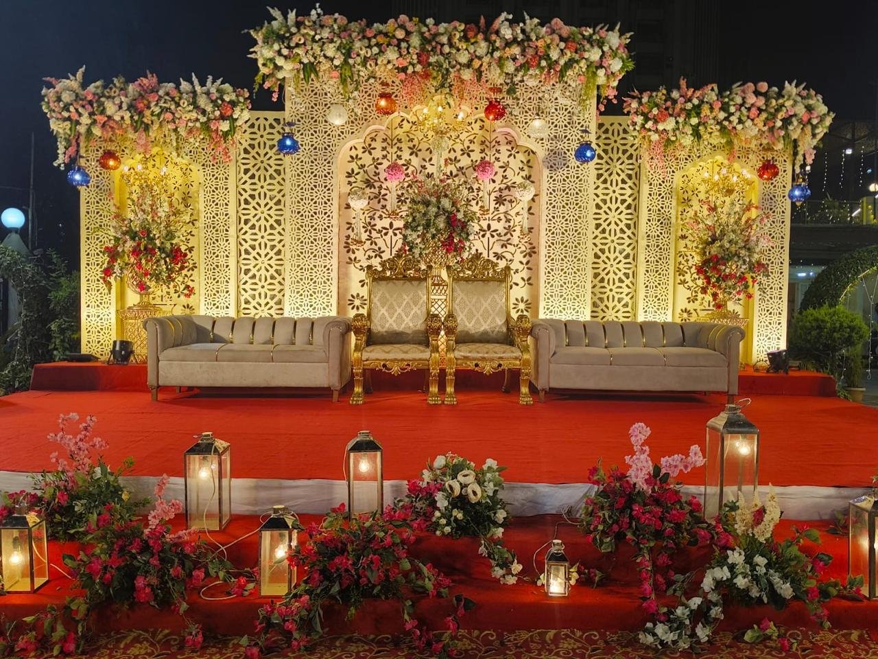 Intimate celebration stage with carved gold lattice and soft lighting
